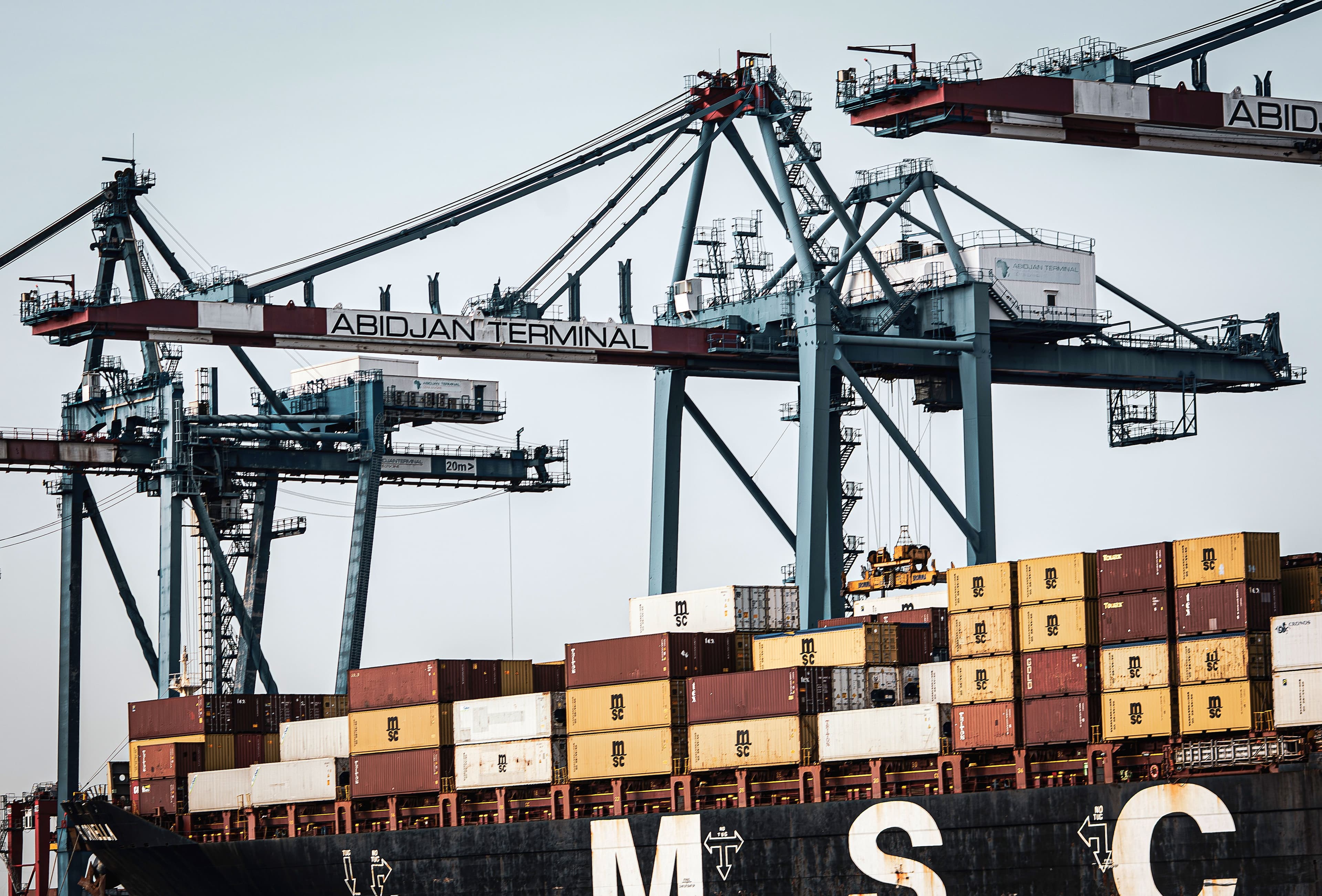 Container cranes and stacked shipping containers at an African port terminal